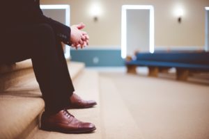 Man on a black suit and brown shoes waiting for his job interview