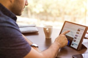 a man going through his LinkedIn newsfeed for possible recruitment opportunities of his connections