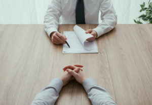 two men in a suit sitting face to face to each other while on a job interview