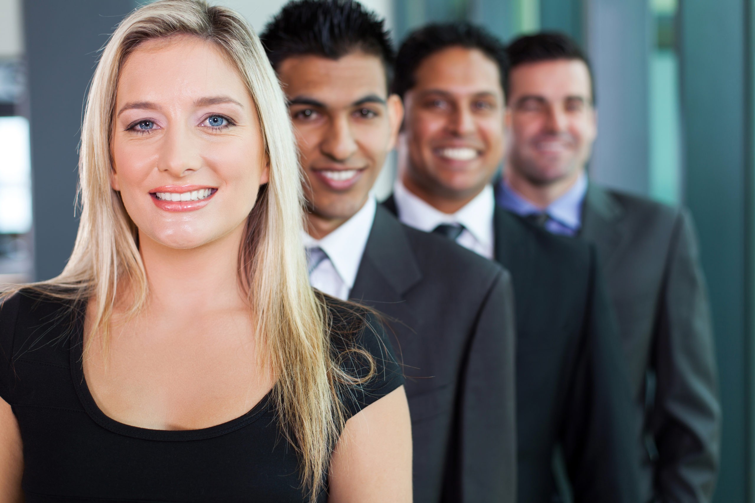 Woman career expert leading the way for 3 men in suits smiling for the camera